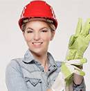 Young female plumber putting on gloves